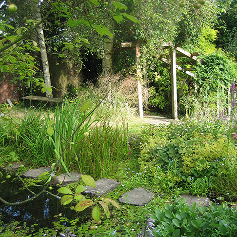 Cohesive garden design of pergola leading onto patio area by Liverpool based design studio. 